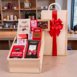 Personalizowany zestaw upominkowy ze słodkościami w drewnianej skrzynce z okazałą kokardą. W skład zestawu wchodzi kawa mielona Espresso Casa, herbata English Breakfast, konfitura z malin oraz praliny. Idealny prezent na drobne okazje z możliwością personalizacji życzeń.